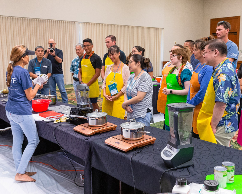 New residents Andrew Kinimaka and Chelsie Moyer learning about Food with the Plant-Based Cooking activity.